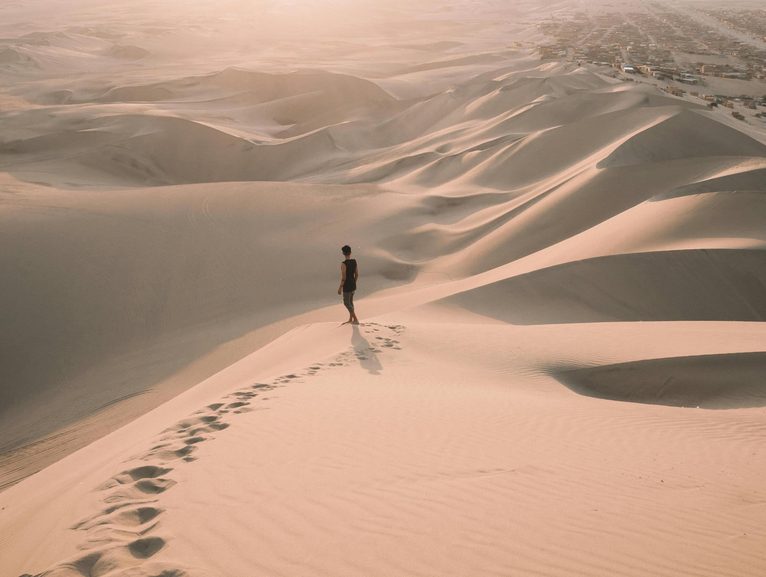 Persona caminando sobre dunas del desierto